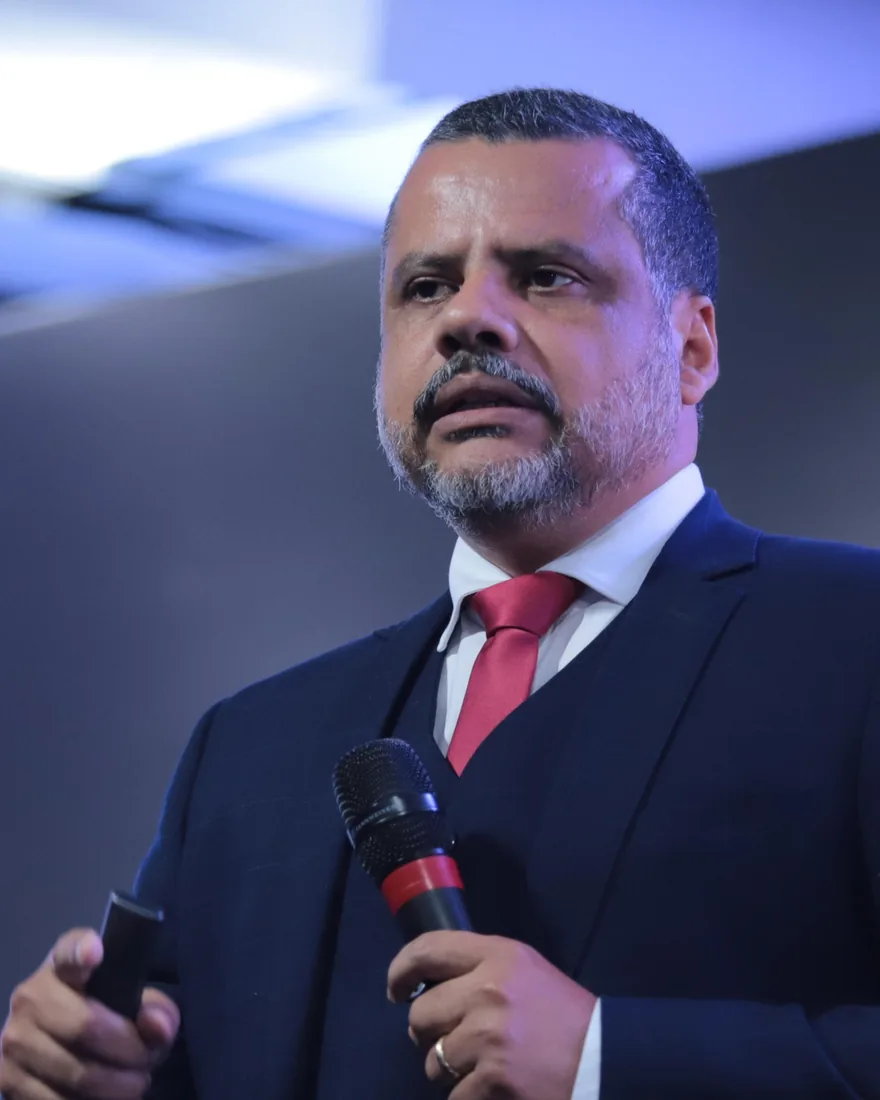 Cleidson Saldanha falando ao microfone num palco